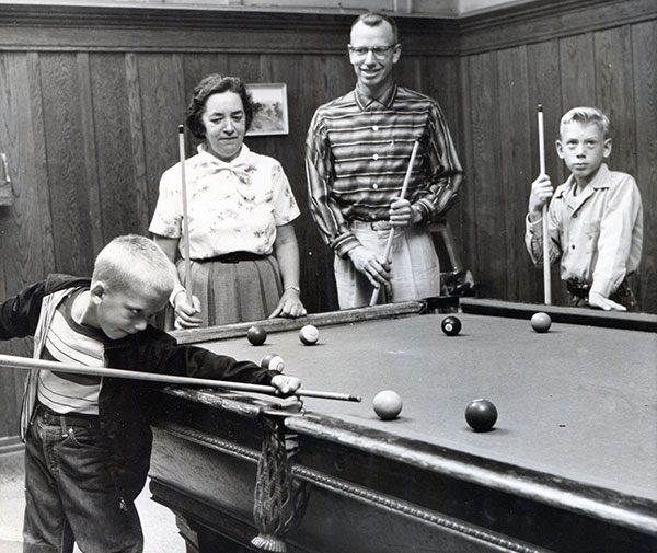 Mark Edelmann (7) shooting pool with his father, Lawrence, and brother, Alan (10), and a Y staff member at the YMCA in 1958.