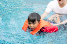 Man teaching boy to swim