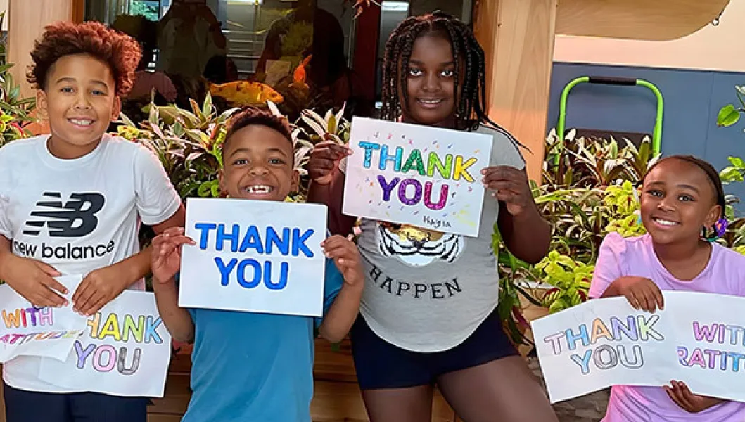 YMCA program participants holding thank you signs
