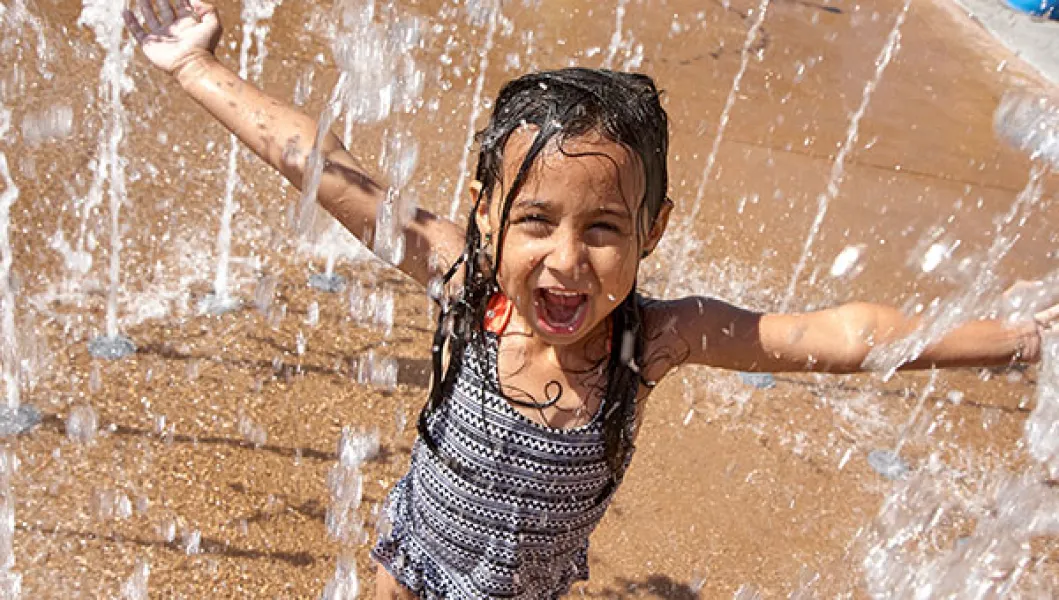 YMCA summer program participant on a splash pad