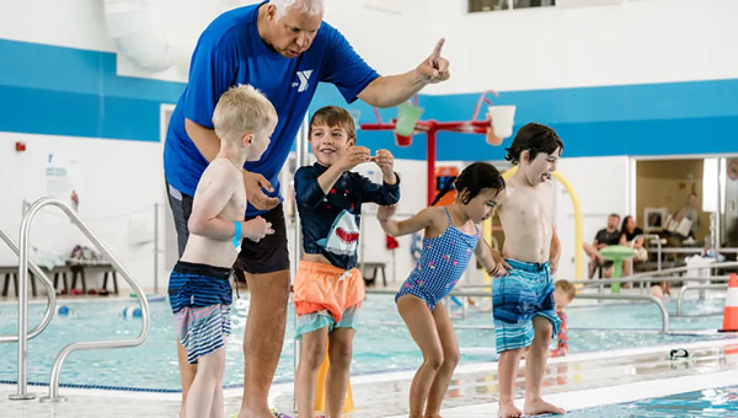 Swim instructor and a group of young students