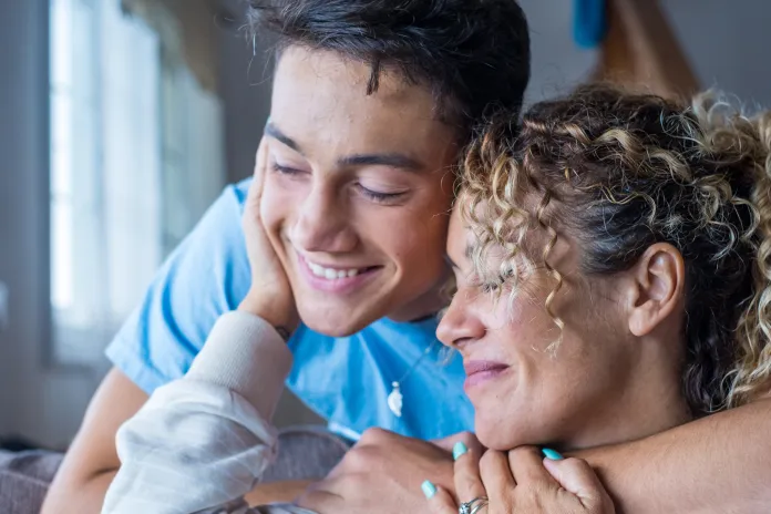Teen hugging woman inside home