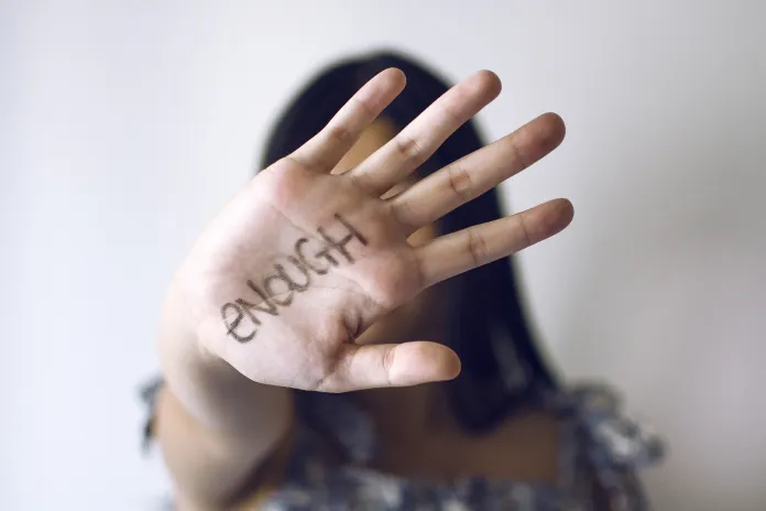 Young woman holding hand up to indicate 'stop'