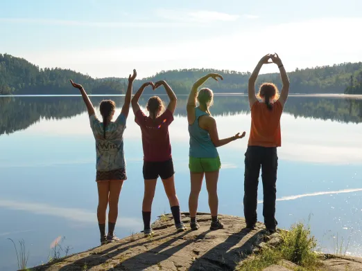 Four teens overlooking lake in YMCA pose