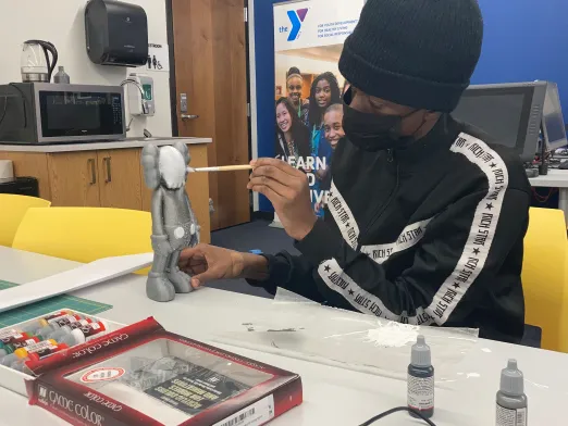 Teen painting Kaws figure