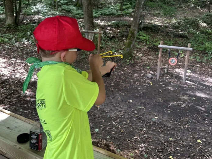 Gus shooting slingshot during afternoon activities