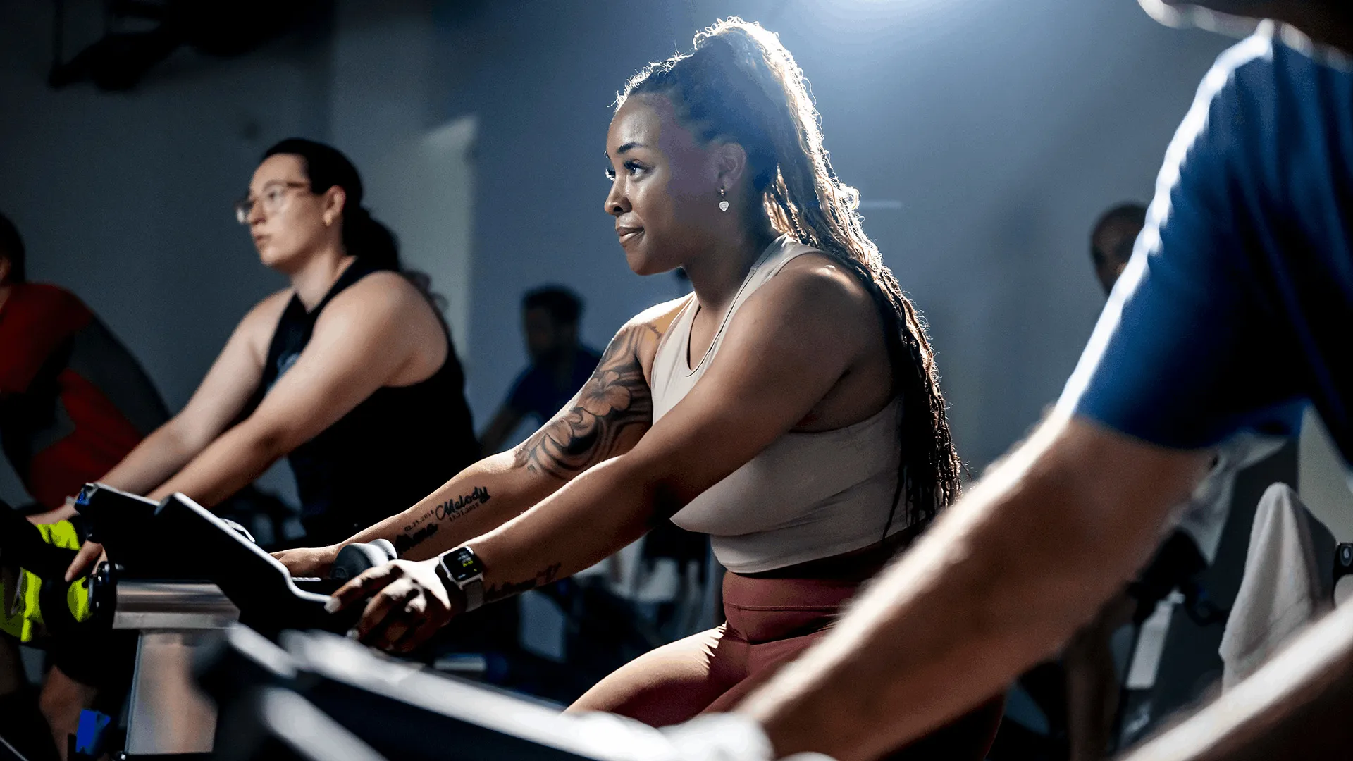 Women working out on an exercise bike who is determined and proud of accomplishment.